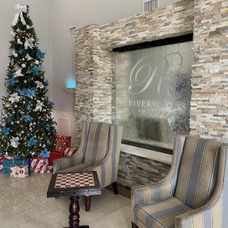 A festive lobby adorned with a beautifully decorated Christmas tree and comfortable seating.