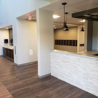 A modern reception area with wood flooring and pendant lighting.