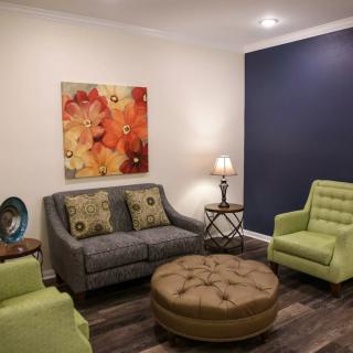 A cozy living room with modern furniture and colorful artwork.