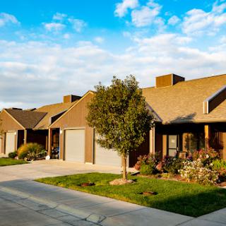 A peaceful neighborhood featuring well-maintained houses under a clear blue sky.