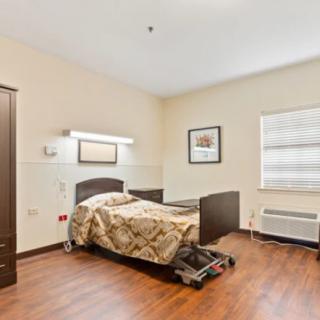 A simple hospital room with a single bed and minimalist decor.