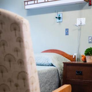 A hospital room with a bed and medical equipment.