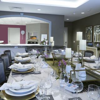 An elegantly set dining table with candles and fine dinnerware in a modern dining room.