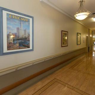 A well-lit hallway with framed artwork on the walls.