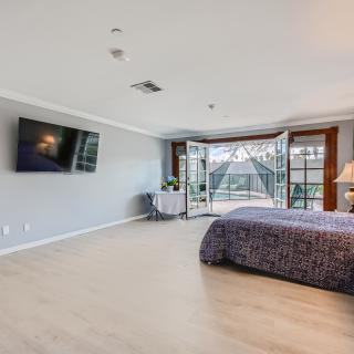 A spacious modern bedroom with large windows allowing natural light to fill the room.