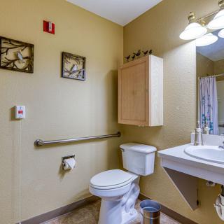 A bathroom featuring a toilet, sink, and decorative wall art.