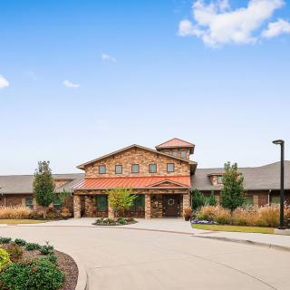 A modern building with landscaped surroundings under a clear blue sky.