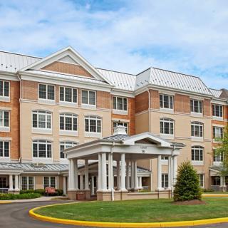 A four-story hotel building with a central entrance and well-maintained landscaping.