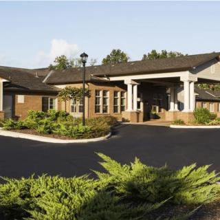 A well-landscaped entrance to a residential building during the daytime.