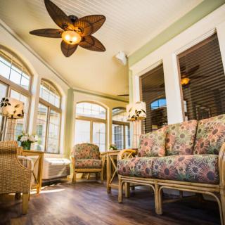 A cozy sunroom with rattan furniture and abundant natural light.