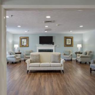 A cozy living room with sofas and chairs arranged around a television.