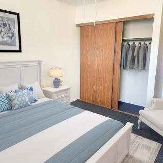 A cozy and modern bedroom featuring a comfortable bed, stylish decor, and a neatly organized closet.