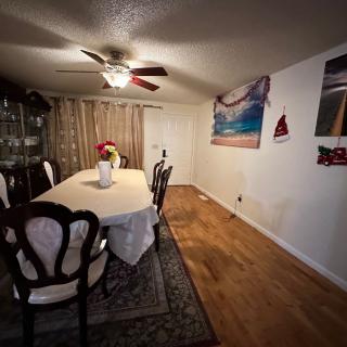 A cozy dining room with a long table, elegant chairs, and warm lighting.