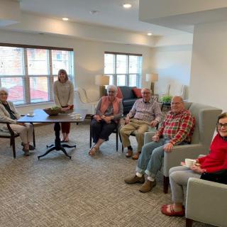 A group of people sitting in a casual meeting setting indoors.