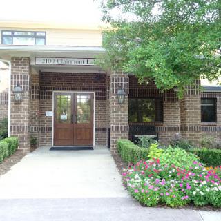 A welcoming entrance with well-maintained landscaping and colorful flowers.