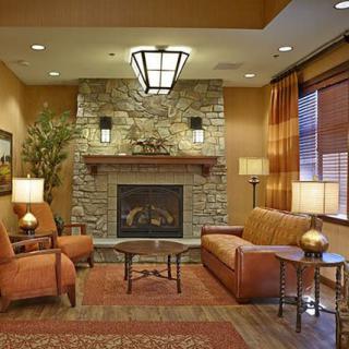 A cozy living room with a stone fireplace, warm lighting, and comfortable seating.