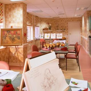 An art studio filled with easels and drawing supplies, showcasing artwork on the walls.