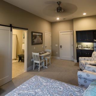 Cozy bedroom interior with a small dining area and bathroom entrance.