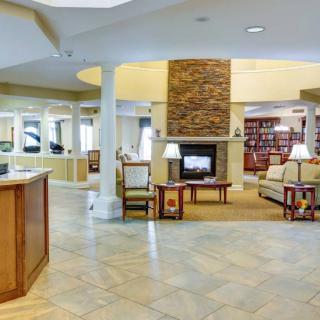A modern lobby with a cozy seating area and a central fireplace.