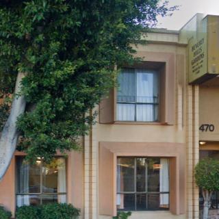 A hotel exterior with windows and surrounding trees.