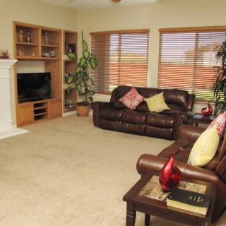 Cozy living room with sofas, a television, and built-in shelves.