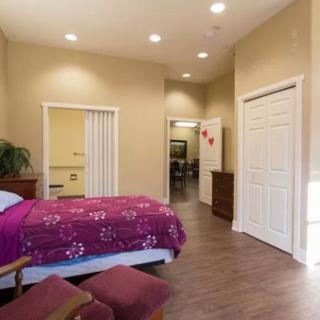A cozy bedroom with a bright pink bedspread and warm lighting.