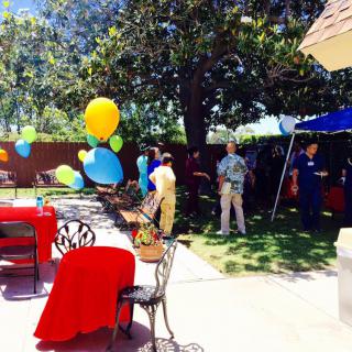 A colorful outdoor party with balloons and decorations in a garden setting.