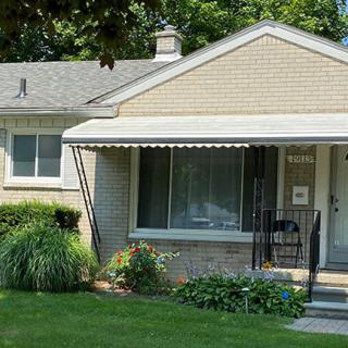 A suburban house with a well-maintained garden and porch.