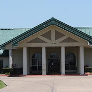 A modern architectural building with a distinctive entrance and green roof.