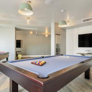 A modern game room featuring a pool table and entertainment setup.