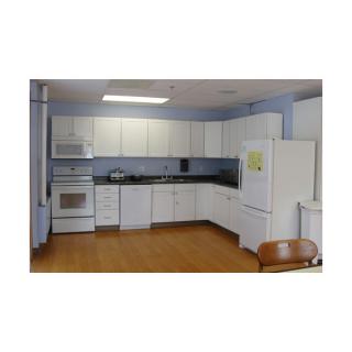 A modern kitchen with white cabinets and various appliances.