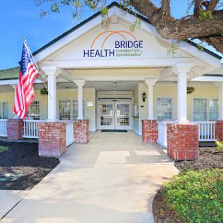 Entrance to a healthcare facility featuring a welcoming porch and American flag.
