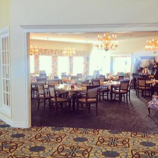 A spacious dining area with neatly arranged tables and chairs, bathed in natural light.