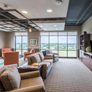 A modern lounge area with comfortable seating and large windows providing a scenic view.