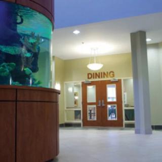 A hallway featuring an aquarium next to the entrance of a dining area.
