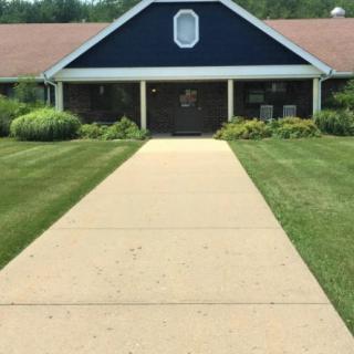 A pathway leading to a building with landscaped lawns on both sides.