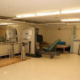 A small gym with exercise equipment and mirrors.