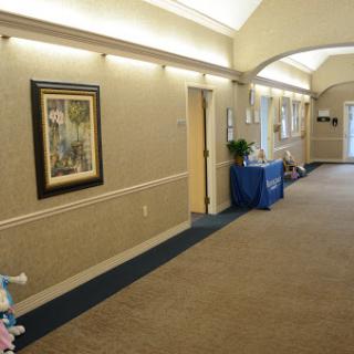 A well-lit interior hallway featuring artwork on the walls and a welcoming atmosphere.