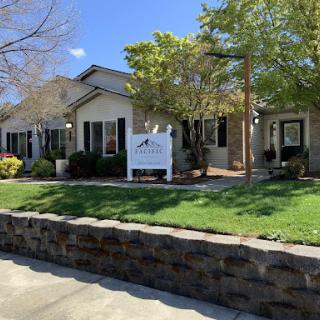 A charming residential building with well-maintained landscaping and a welcoming sign.