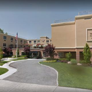 A healthcare facility with landscaped grounds and a clear pathway.