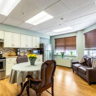 A cozy and modern kitchen area featuring a dining table, comfortable seating, and well-equipped appliances.