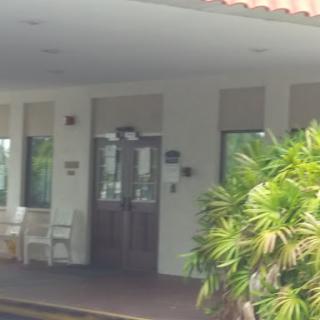 A welcoming entrance with a wooden door and outdoor seating, surrounded by greenery.