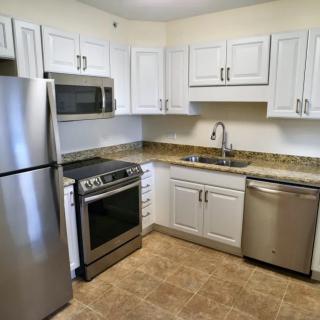 A modern kitchen featuring stainless steel appliances and white cabinets.