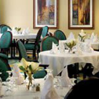 A beautifully arranged dining area with elegantly set tables and chairs, ready for guests.