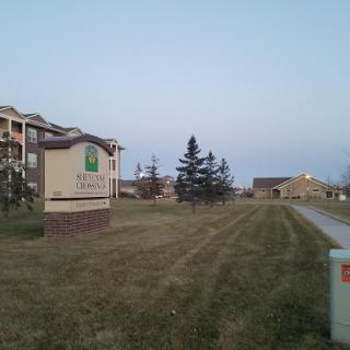 Exterior view of a hotel or apartment complex along a pathway near greenery.