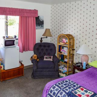 A cozy living room with a comfortable armchair, a small bookshelf, and decorative elements.