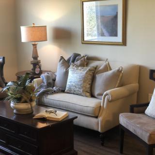 A cozy living room with a comfortable sofa, armchair, and decorative elements.