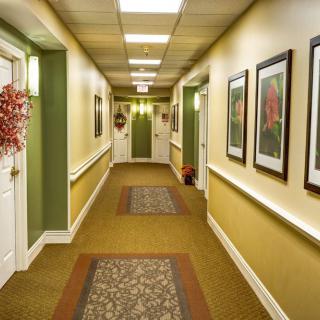 A well-decorated hallway with framed artwork and carpeted flooring.