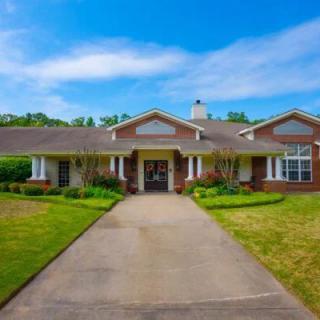 A single-story brick house with a driveway and well-maintained lawn.