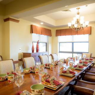 An elegant dining room with a beautifully set table and chandelier lighting.